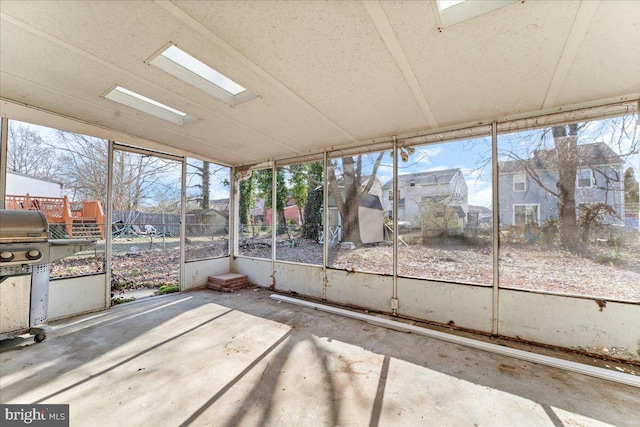 unfurnished sunroom featuring a skylight