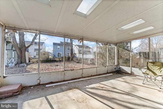 unfurnished sunroom featuring a skylight