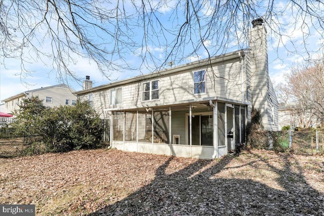 rear view of property featuring a sunroom