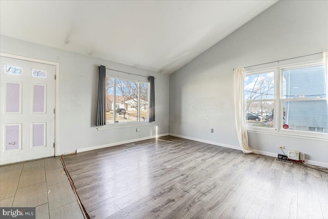 spare room featuring hardwood / wood-style flooring and vaulted ceiling