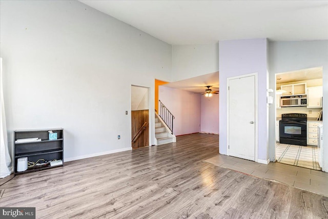 unfurnished living room with ceiling fan, light hardwood / wood-style flooring, and high vaulted ceiling