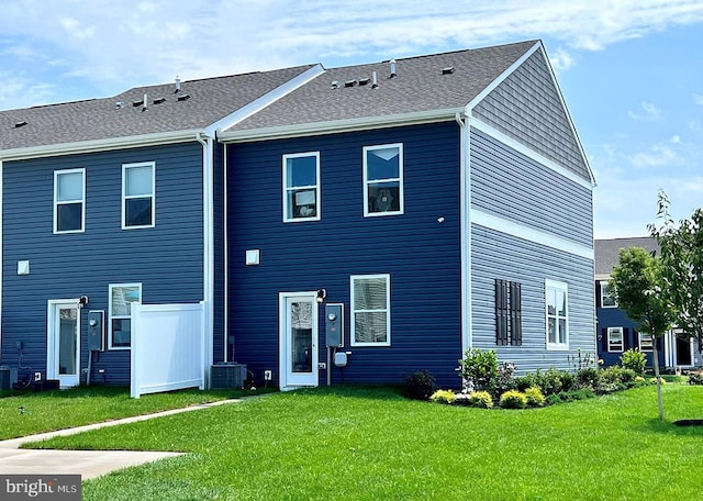 rear view of property featuring central AC unit and a yard