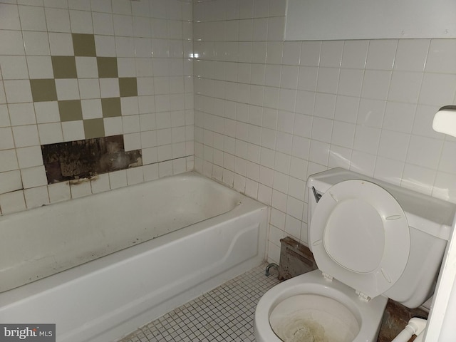 bathroom featuring tile patterned flooring, tile walls, a bathtub, and toilet