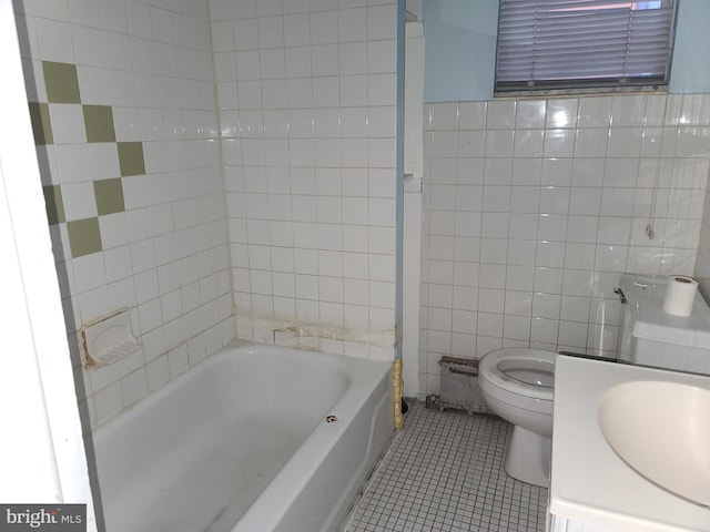 bathroom with tile patterned flooring, tile walls, a washtub, and toilet