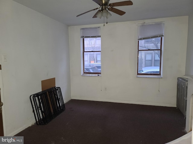 unfurnished room with ceiling fan, radiator heating unit, and plenty of natural light