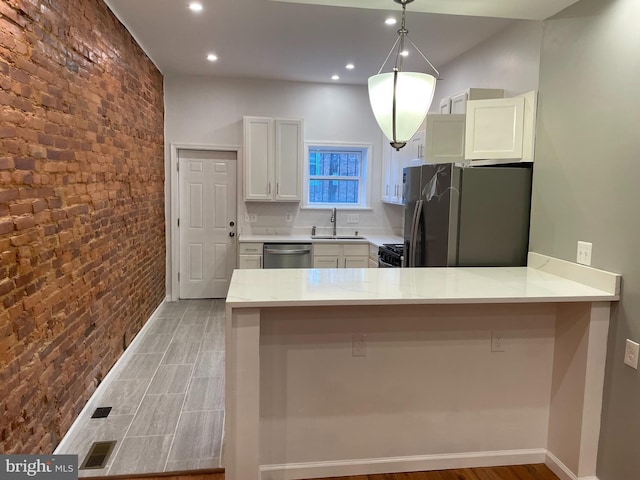 kitchen with pendant lighting, white cabinetry, a kitchen bar, kitchen peninsula, and stainless steel appliances