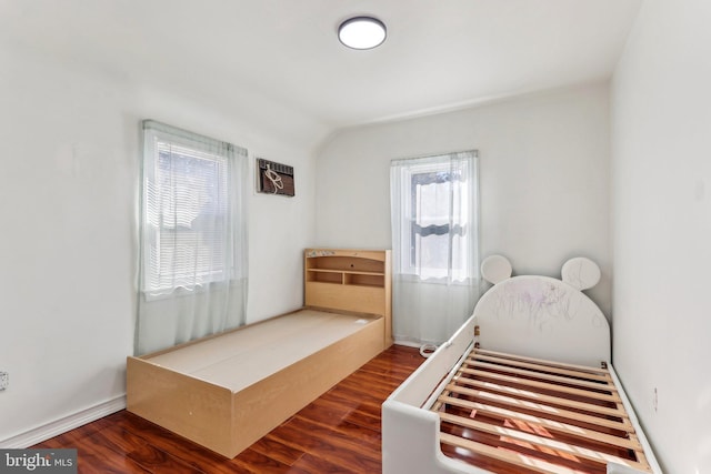 bedroom with dark wood-type flooring and an AC wall unit