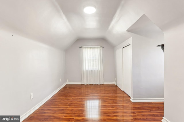 additional living space featuring baseboards, vaulted ceiling, and wood finished floors