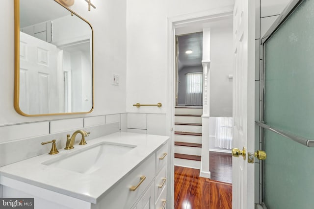 bathroom featuring decorative backsplash, wood finished floors, and vanity