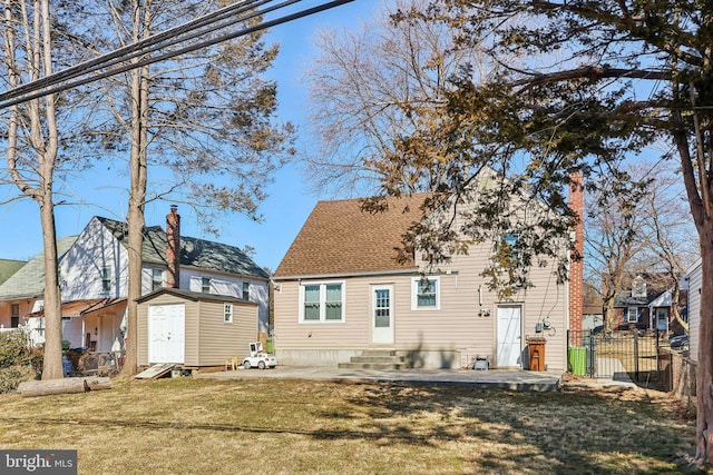 rear view of property featuring an outbuilding, a storage shed, entry steps, a patio area, and fence