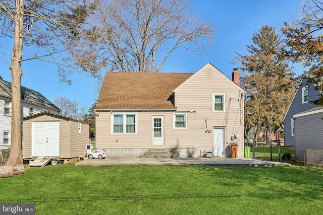 back of property with a yard, a storage shed, entry steps, fence, and an outdoor structure