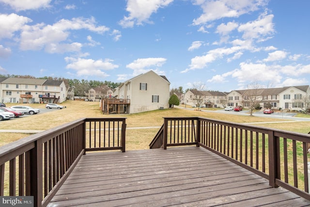 wooden deck with a residential view and a lawn