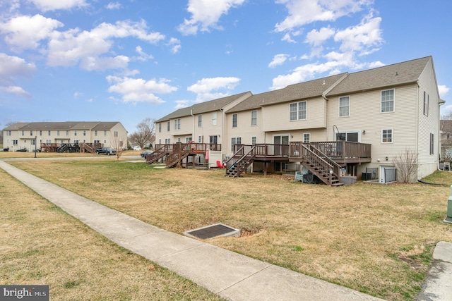 back of house featuring stairway, a yard, a residential view, and a wooden deck