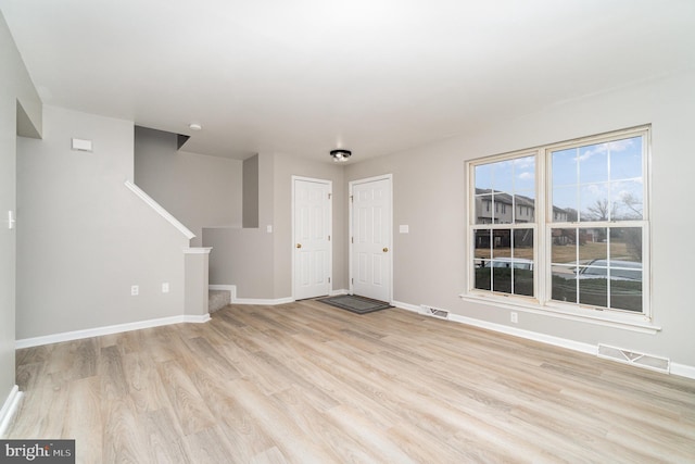 entrance foyer with stairs, baseboards, visible vents, and light wood-type flooring