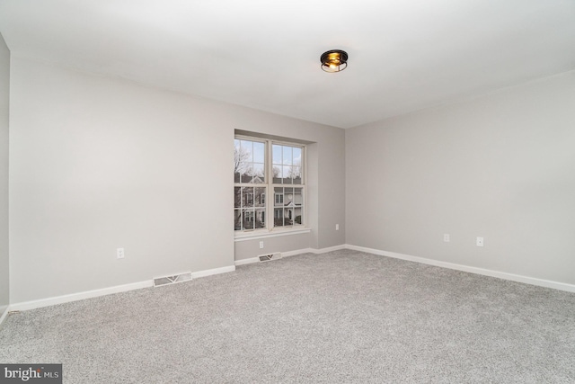 carpeted empty room with visible vents and baseboards