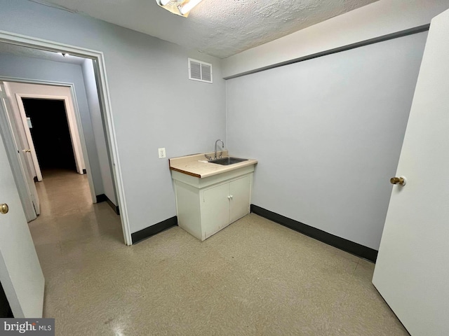 interior space featuring sink and a textured ceiling