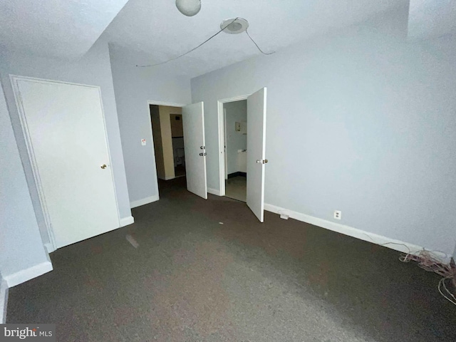 unfurnished bedroom featuring dark carpet