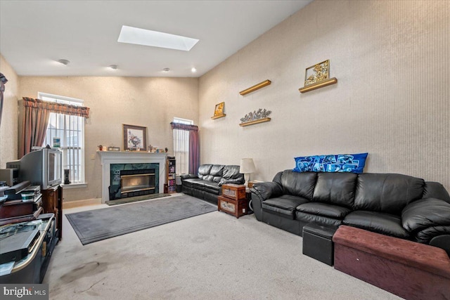 living room with carpet, a skylight, and a premium fireplace