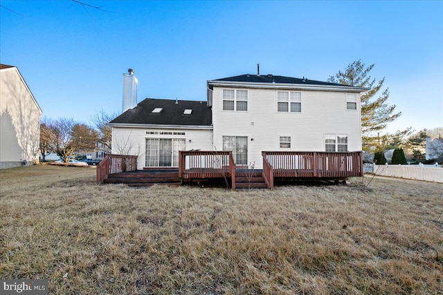 rear view of property with a lawn and a wooden deck