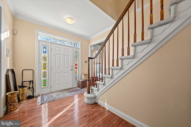 foyer entrance featuring crown molding and wood-type flooring