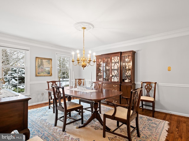 dining area featuring hardwood / wood-style flooring, crown molding, and a notable chandelier