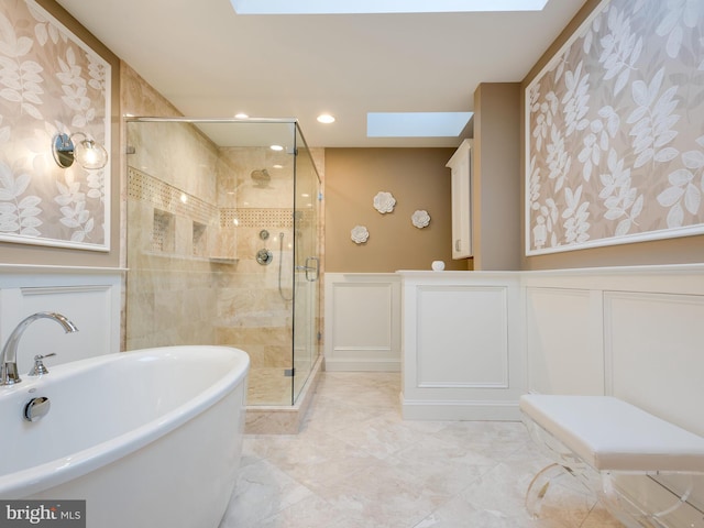 bathroom featuring a skylight and separate shower and tub