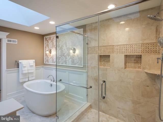 bathroom featuring a skylight and independent shower and bath