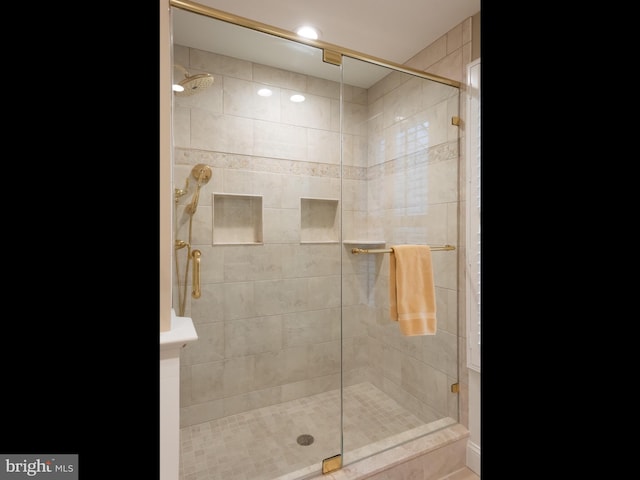 bathroom featuring a shower with door