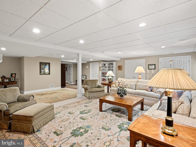 living room featuring light colored carpet and a drop ceiling