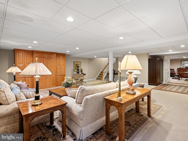 living room featuring a paneled ceiling and carpet flooring