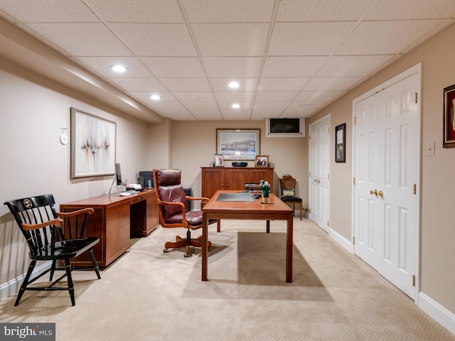 carpeted home office with a drop ceiling