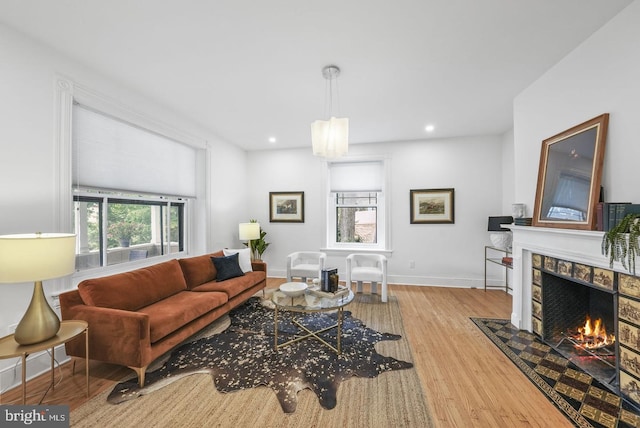 living room featuring a tile fireplace and light hardwood / wood-style floors