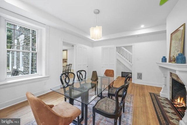 dining space with hardwood / wood-style floors, a wealth of natural light, and a fireplace