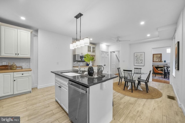 kitchen with sink, white cabinetry, a center island with sink, light hardwood / wood-style flooring, and stainless steel dishwasher