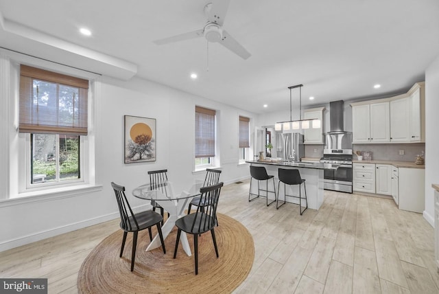 dining area with light hardwood / wood-style flooring and ceiling fan