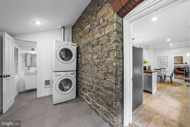 clothes washing area featuring stacked washer / dryer