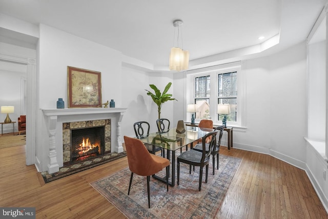 dining area with hardwood / wood-style flooring and a fireplace