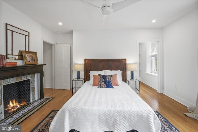 bedroom with light hardwood / wood-style flooring and a fireplace