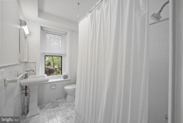 bathroom featuring sink, tile walls, toilet, tile patterned floors, and a shower with shower curtain