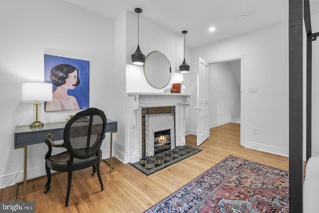 office featuring wood-type flooring and a fireplace