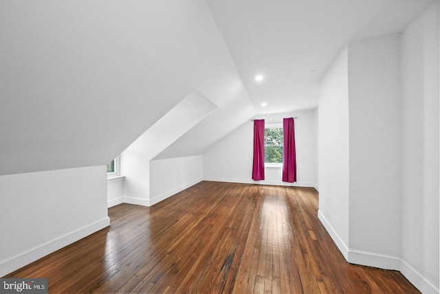 bonus room with dark wood-type flooring and vaulted ceiling