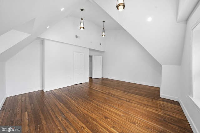 bonus room with vaulted ceiling and dark wood-type flooring