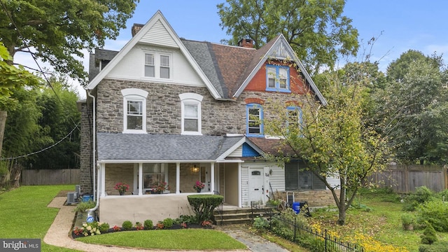 view of front of property with a porch, a front yard, and central air condition unit