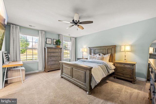 bedroom featuring baseboards, ceiling fan, light colored carpet, and visible vents