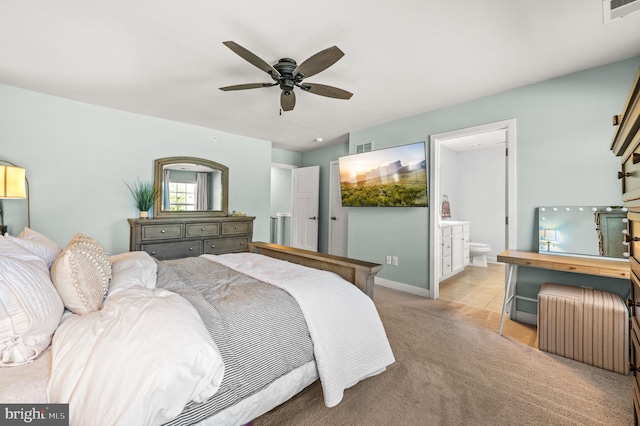 bedroom featuring light colored carpet, ceiling fan, visible vents, and ensuite bath