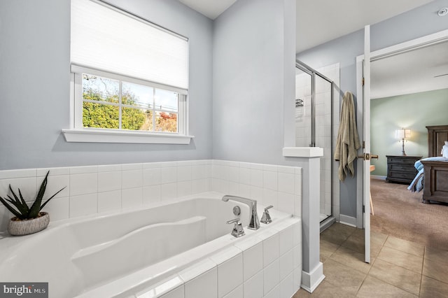 ensuite bathroom with baseboards, ensuite bathroom, a stall shower, and a garden tub