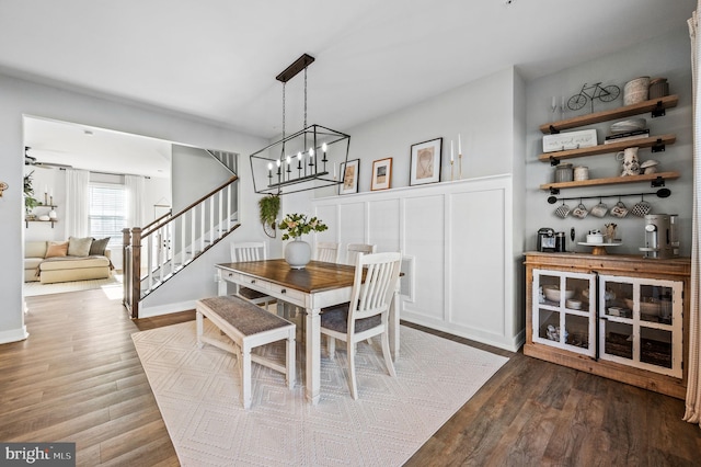 dining space featuring wood finished floors and stairway