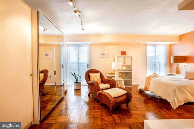 bedroom featuring rail lighting and baseboards