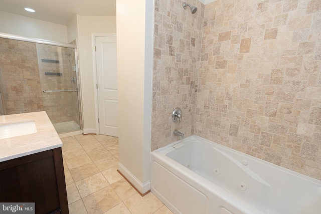 bathroom featuring tiled shower / bath, vanity, and tile patterned flooring
