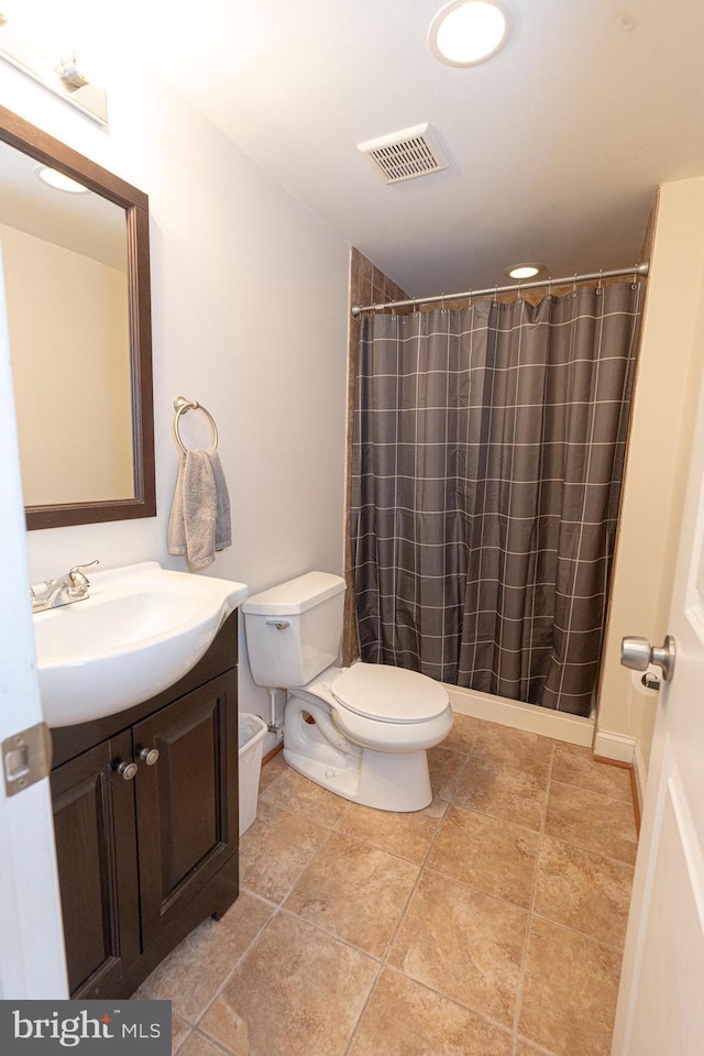 bathroom featuring toilet, vanity, and curtained shower